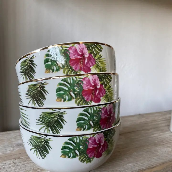 Fire stabelt porcelænsskåle med grønne tropiske blade og lyserøde blomster på ydersiden, placeret på et lyst træbord. (2)