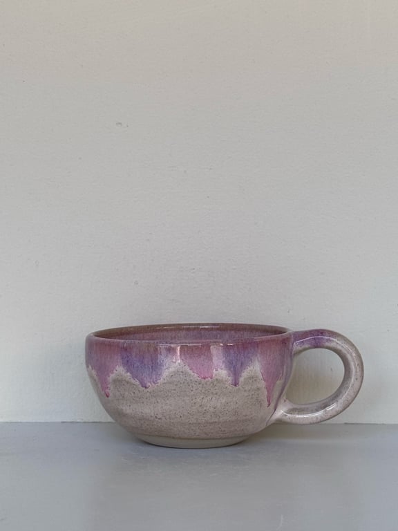 Lilla og beige keramisk kop med stort håndtag.