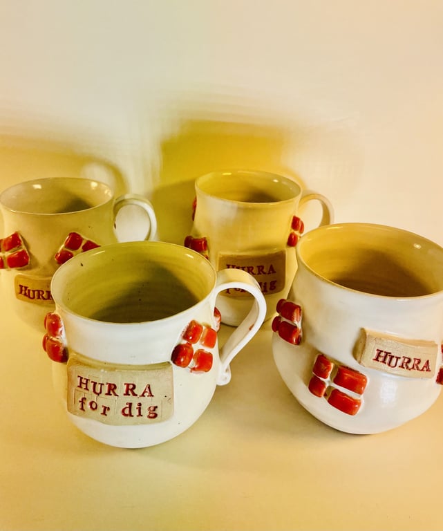 Fire keramikkrus med røde dekorationer og tekster på dansk, herunder "HURRA for dig" og "HURRA".