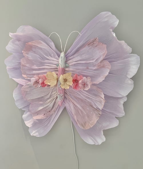 Sommerfugl lavet af fine, lyslilla blomsterblade med små gule og lyserøde blomster som dekoration på en lys baggrund. (1)