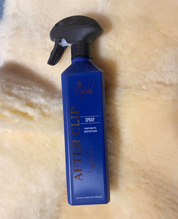 Flaske med blå spray til hestepleje mærket Nathalie After Clip, der forebygger irritation.
