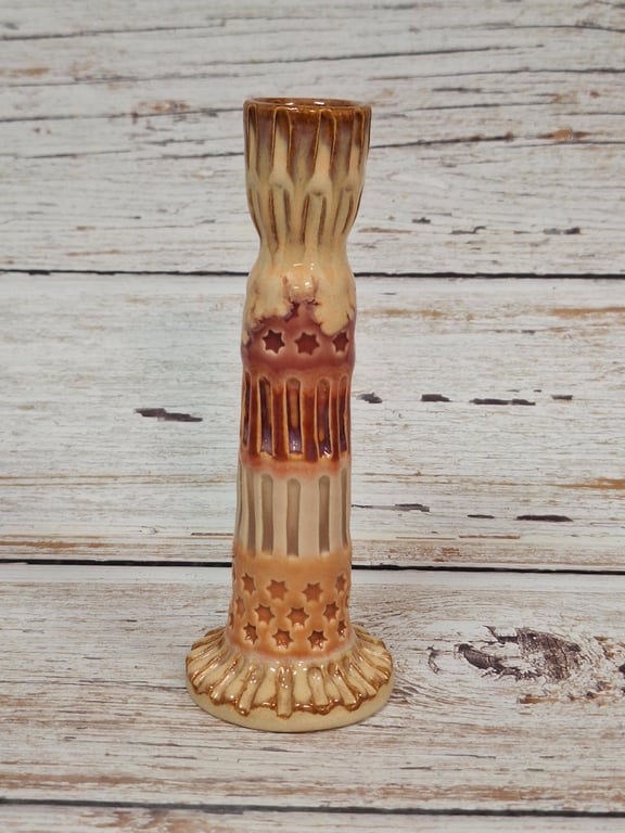 Keramisk lysestage med stjernemønster og brun-beige glasur.