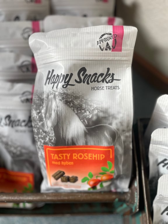 Pose med hestegodbidder "Happy Snacks" med hyben smag, dekoreret med billede af hest og rosenfrugter.