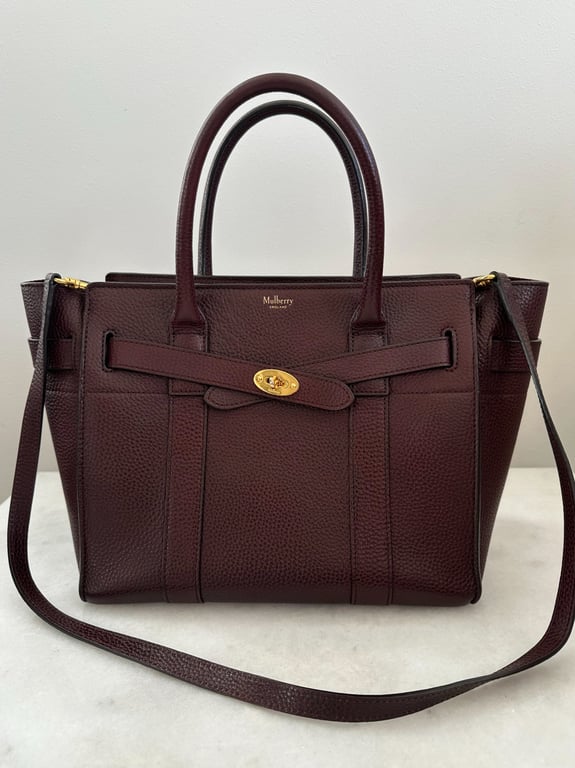 Bordeauxfarvet Mulberry lædertaske med to håndtag, skulderrem og guldfarvet lås foran.