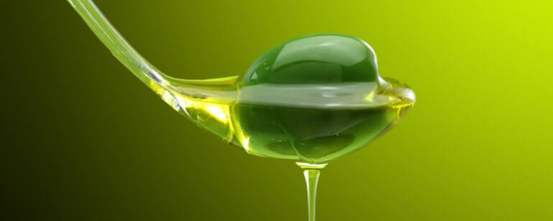 En close-up af en ske fyldt med grøn olie, dryppende mod en gulgrøn baggrund, med dansk tekst, der reklamerer for en gratis økologisk tomatplant.