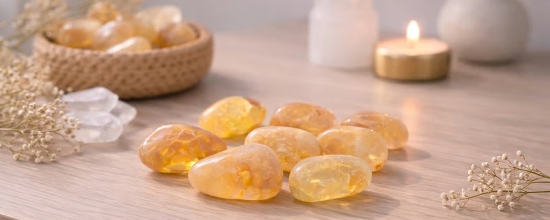 Et gaveæske med brunt fyldpapir, et kort med dansk tekst om kærlighed, en guldring med oval sten og et lyserødt armbånd.