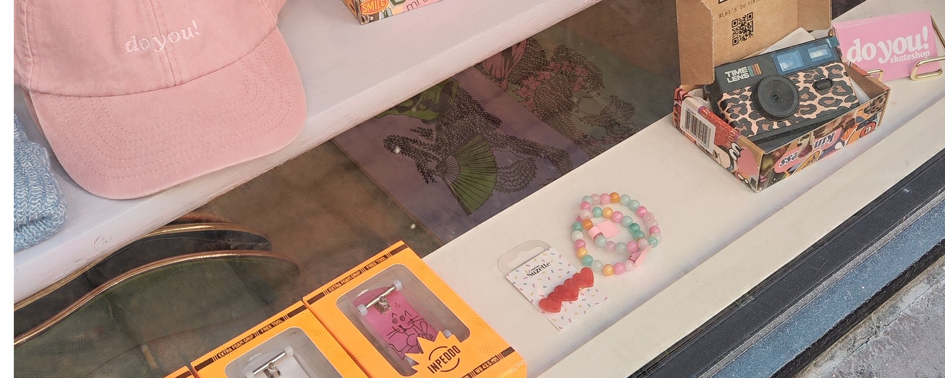 Person med tatoverede arme strammer skruer på et skateboard.