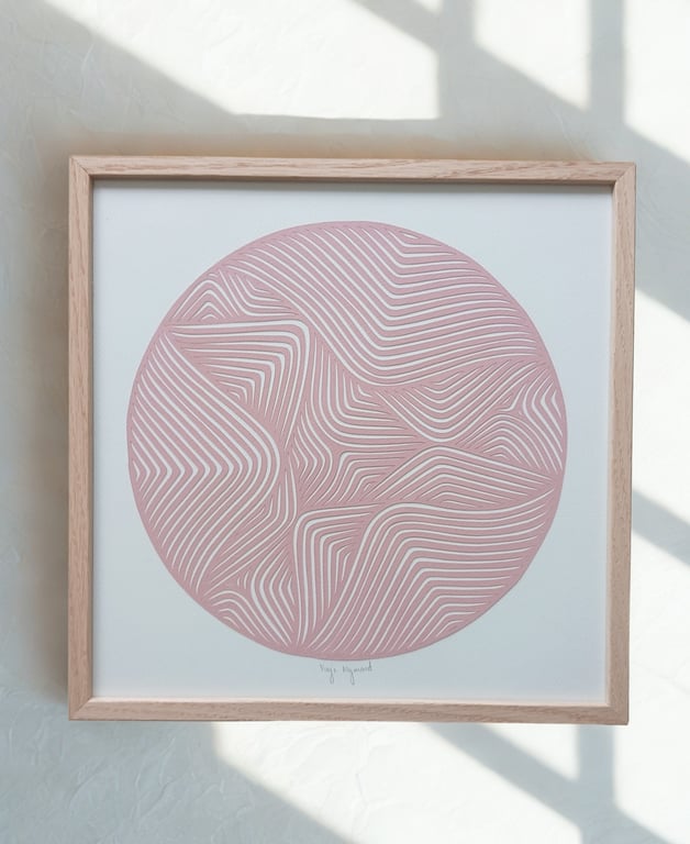 Indrammet abstrakt kunstværk med rosa cirkel fyldt med hvide, bølgende og vinkelformede linjer på hvid baggrund.