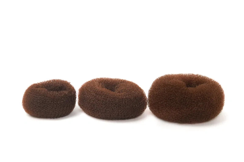 Tre brune hårdonuts i forskellige størrelser på hvid baggrund.