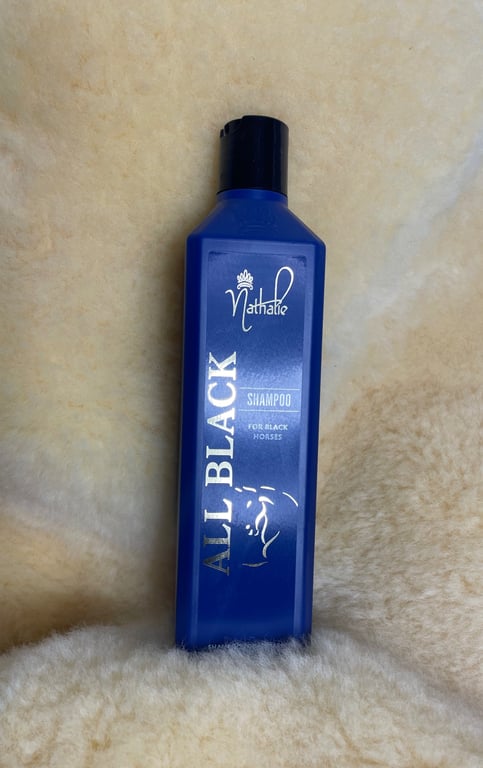Blå flaske med Nathalie All Black shampoo til sorte heste, placeret på lyst uldstof.