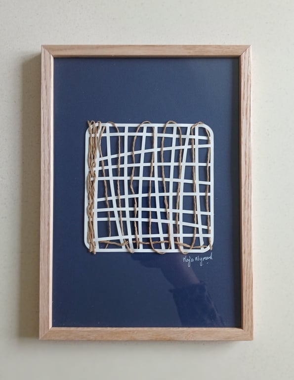 Indrammet abstrakt kunstværk med hvide, overlappende linjer og tynde snore viklet vertikalt omkring et mørkeblåt baggrundsark.