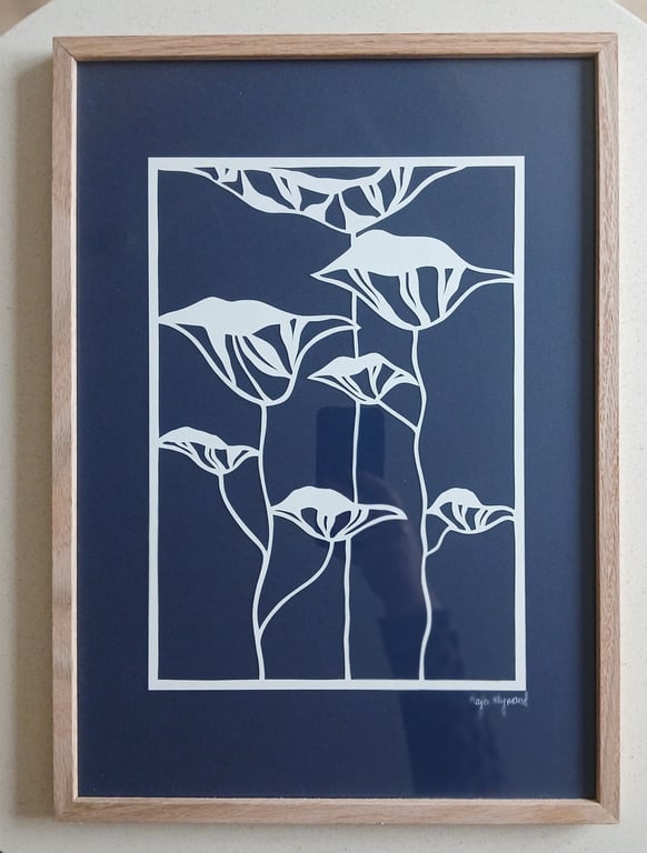 Billedramme med minimalistisk, hvid blomsterillustration på mørkeblå baggrund.