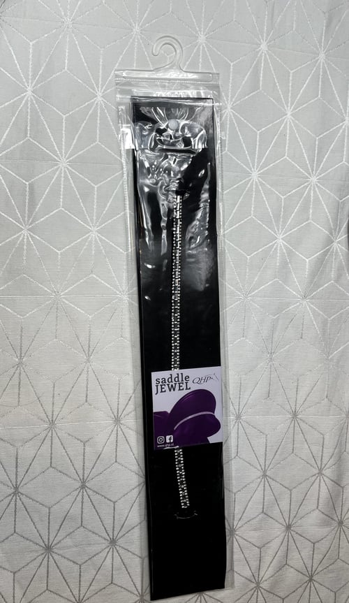 Sadel smykke kaldet "Saddle Jewel" i klar plastikemballage med et glitrende kæde vedhæftede. (1)