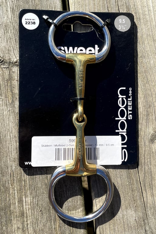 Biddel i metal med både kobber og rustfrit stål, monteret på sort emballage med teksten "Stübben."