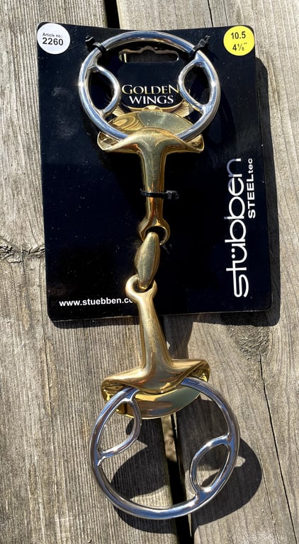 Biddet "Golden Wings" fra Stübben på sort emballage, placeret på træbord.