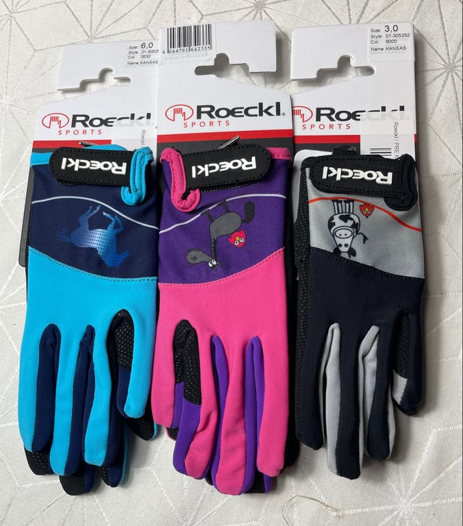 Tre par farverige Roeckl sports handsker til børn, på original emballage, hver med unikt dyrprint i blå, pink/lilla og grå/sort farver.