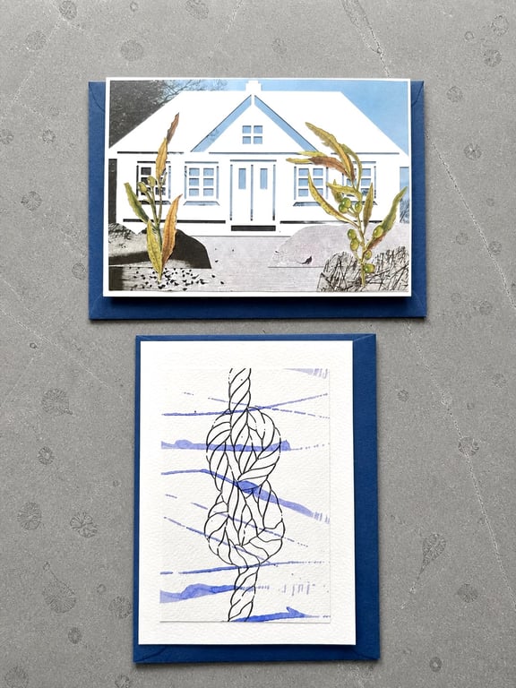 To kort med blå kuverter på en grå overflade; det øverste kort viser et hvidt hus med planter foran, det nederste kort viser en abstrakt sort tegning med blå akvarelstreg.