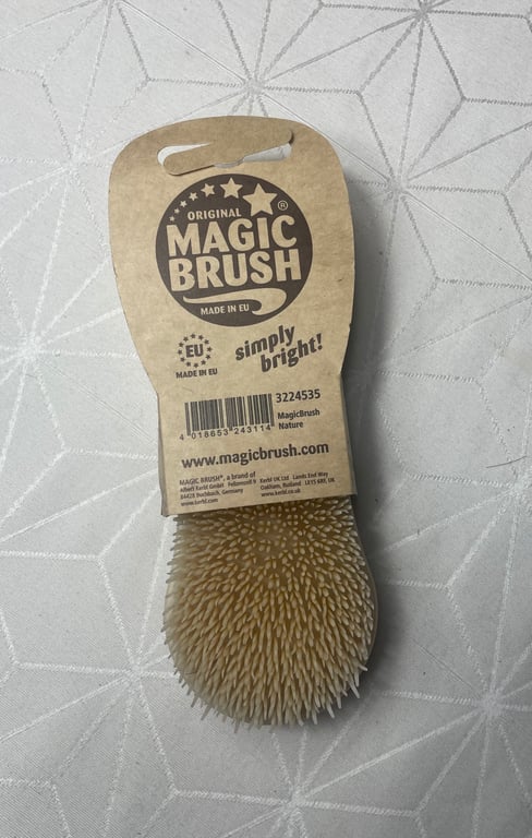 Billede af en Original Magic Brush med naturbørste og papiretikette, der viser produktets navn og tekst "simply bright!" samt oplysninger om, at den er lavet i EU.