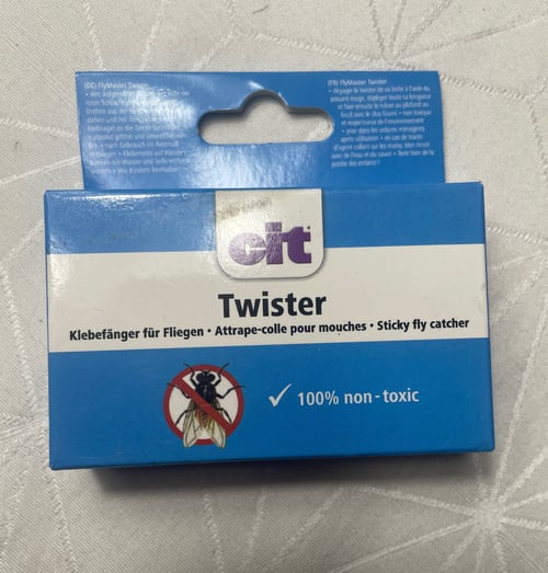 Pakke med blå og hvid etikette til "cit Twister", en klistret fluefanger, mærket som 100% ikke-giftig, med tekst på tysk, fransk og engelsk. (1)