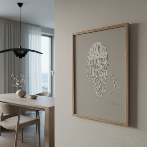 Billede af en lysegrå væg med en indrammet minimalistisk plakat af en manet i hvidt, med et lyst træramme, ved siden af et lyst spisestueområde med bord, stole og en sort loftlampe. (1)