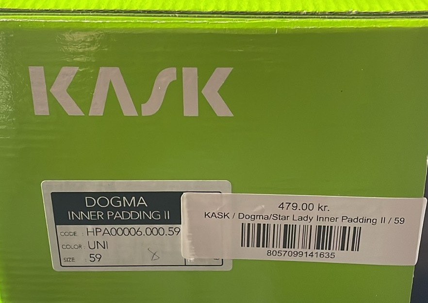 Grøn kasse med mærke "KASK" og etiketter, der viser modelnavnet "Dogma Inner Padding II," størrelse 59, farve UNI og prisen 479,00 kr.