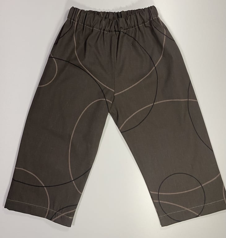 Bukser til børn i brun med elastisk talje og mønster af store cirkler.