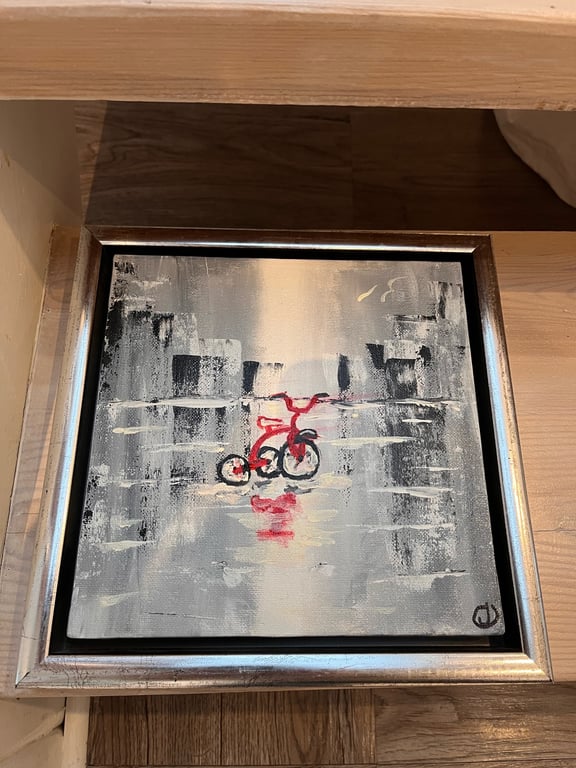 Maleri af en rød cykel med refleksion på en våd, abstrakt bybaggrund i grå og hvide nuancer.