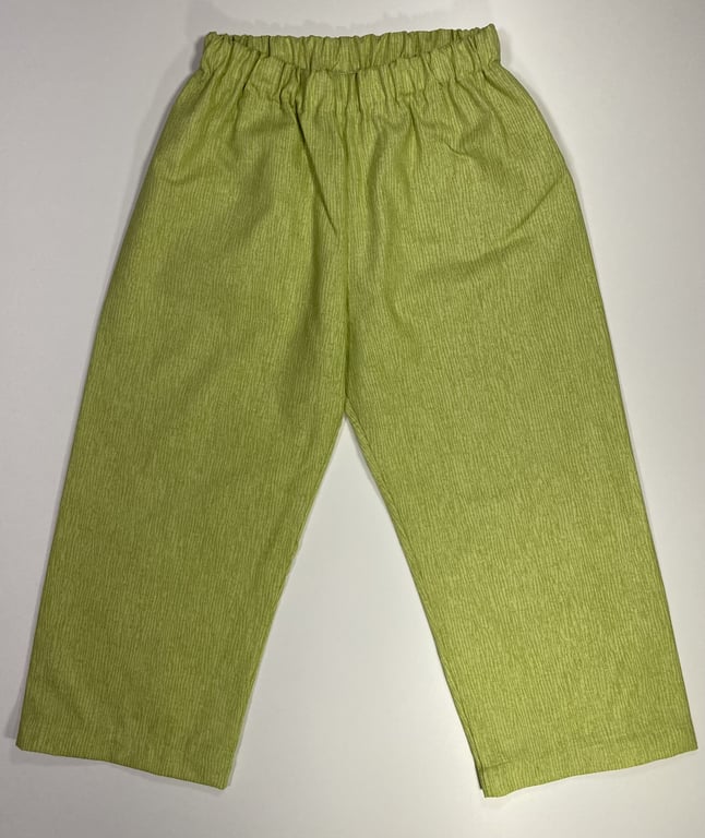 Bukser i lysegrøn med elastisk talje, lagt fladt på hvid baggrund.