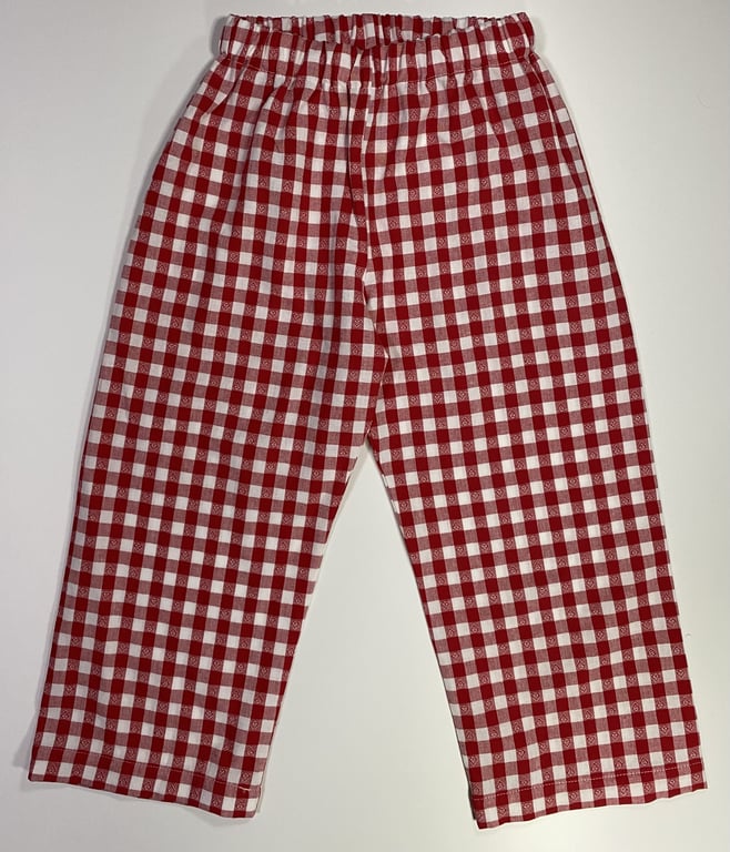 Røde og hvide ternede pyjamasbukser med elastisk talje på hvid baggrund.