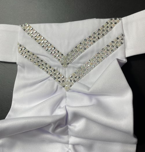 Hvidt stof med to V-formede rækker af små glitrende perler og sten på en sort baggrund. (1)