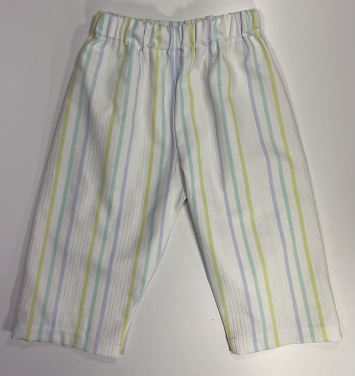 Babybukser med elastisk talje og vertikale striber i blå, grøn og gul på hvid baggrund.