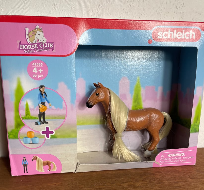 Legetøjspakke med brun hest med lys manke og hale fra Schleich Horse Club Sofia's Beauties, aldersanbefaling 4+, inddelt i lyserød og blå emballage.
