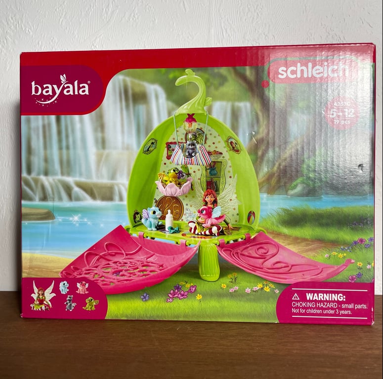 Legetøjssæt fra Bayala med et grønt og lyserødt blomsterdesign, som åbner op til en lille eventyrverden med fe- og dyrefigurer.