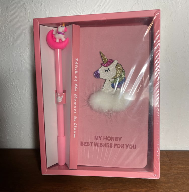 Gaveæske med en pink pen med en enhjørning på toppen og en lyserød notesbog med en glitrende enhjørning og teksten "MY HONEY BEST WISHES FOR YOU".
