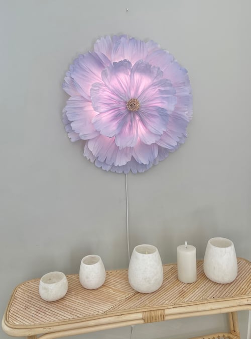 Vægophængt lampe formet som en stor lyserød blomst over et bambusbord med fem hvide stearinlys og lysestager. (1)