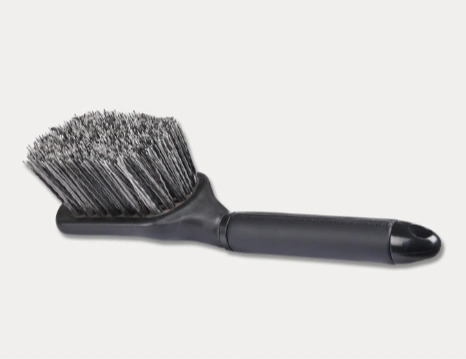 Børste med sorte og grå børstehår og sort plastik håndtag.