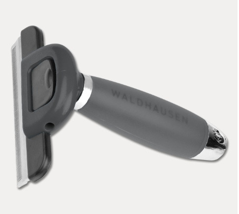 Kattekam med gråt håndtag og metalblad, mærket "Waldhausen".