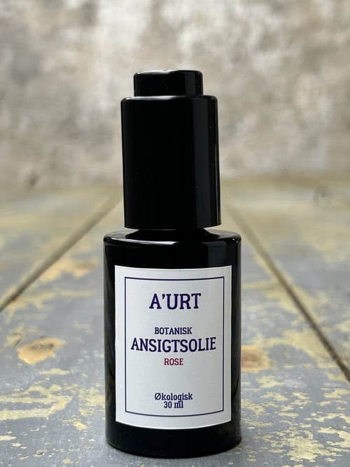 Sort flaske med label på fronten, der beskriver A'URT botanisk ansigtsolie med rose, 30 ml, økologisk. (1)