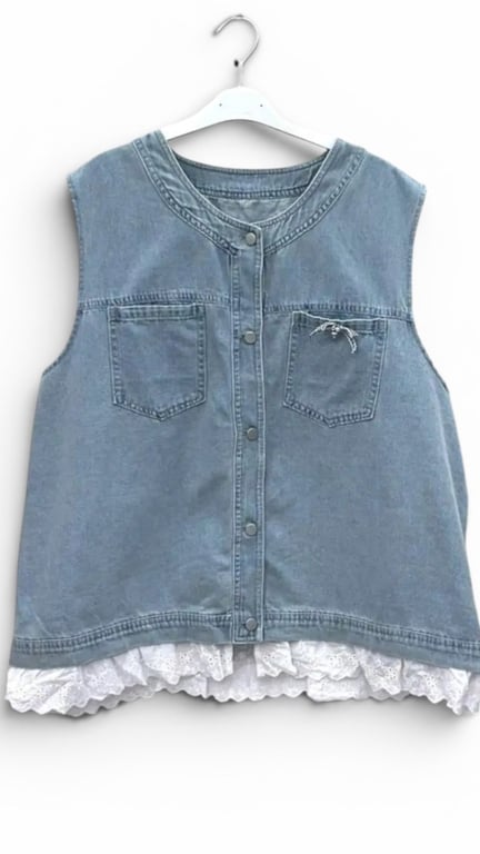 Blå denim vest uden ærmer med knapper foran, to brystlommer og hvidt blonderkant forneden, hængende på hvid bøjle.