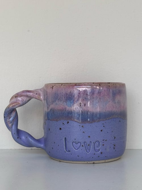 Keramisk kop i lilla og pink med flettet hank og teksten "Love" indgraveret på forsiden. (1)