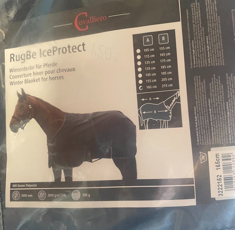 Et billede af emballage til en hestetæppe med mærket Cavalliero, navnet RugBe IceProtect, og tekst på flere sprog, der beskriver det som et vintertæppe til heste. Emballagen viser størrelsesoversigt og illustration af tæppets pasform på en hest, sa