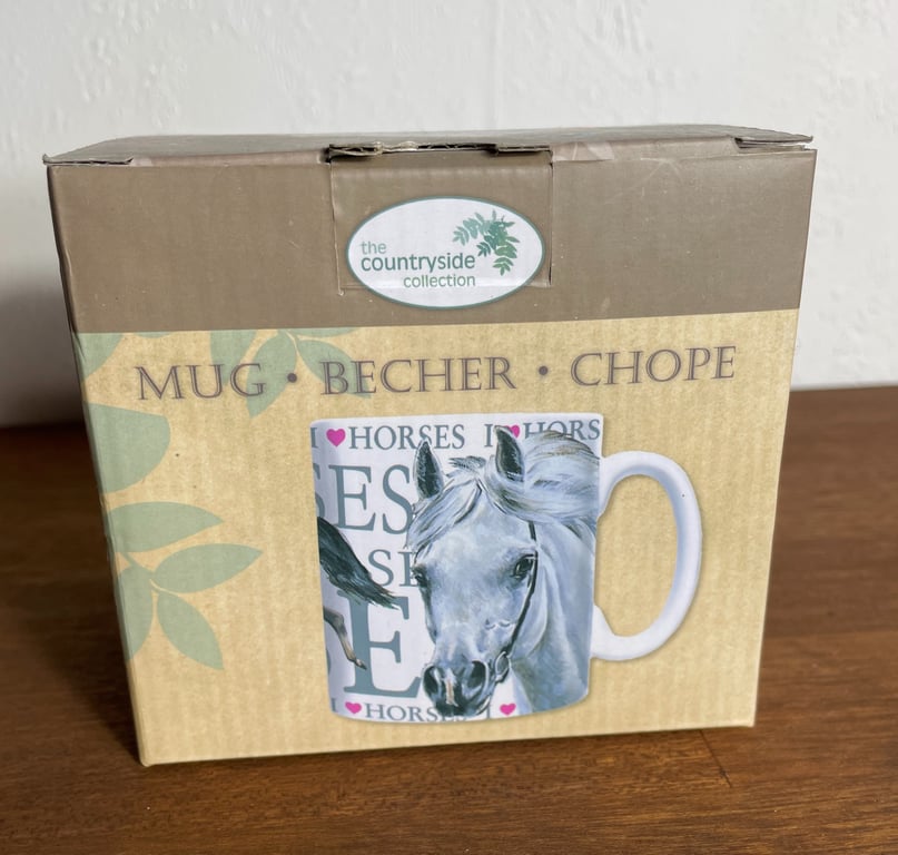 Billede af en indpakning til en kop med hestemotiv fra "the countryside collection", med ordene "Mug", "Becher" og "Chope" på forsiden.