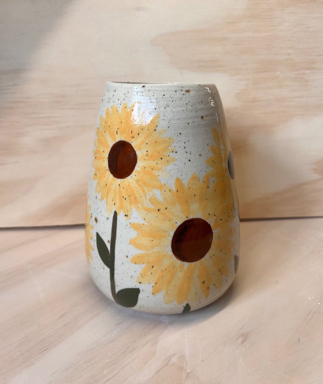 Keramisk vase med håndmalede solsikker på hvid baggrund.
