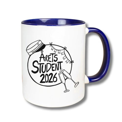 Hvid krus med blå hank og kant med tekst "Årets Student 2026" omgivet af illustrationer af en studenterhue, guirlander og to skåleglas. (1)