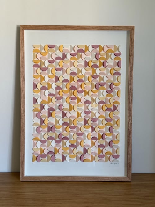 Indrammet abstrakt kunsttryk med geometrisk mønster bestående af gentagne buede former i nuancer af gul, rosa, lyserød og lilla på hvid baggrund. (2)