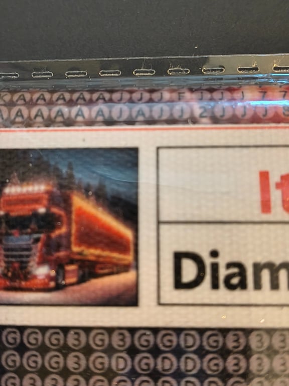 Nærbillede af en del af et lodseddel med et billede af en oplyst lastbil i natten og tekst, der indeholder ordet "Diamond".