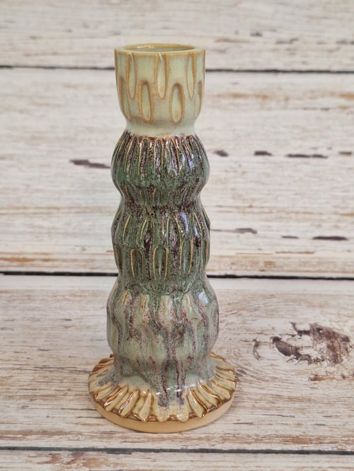 Keramisk, vådt udseende, grøn og beige vase med bølgede mønstre, placeret på lyst træbord. (1)