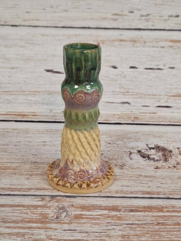 Keramisk vintage lysestage med grøn, lilla og beige glasur, pyntet med cirkel- og bladmønstre.