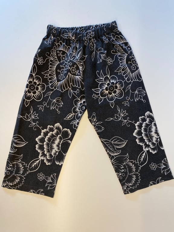 Bukser med elastisk talje, sort bundfarve med store hvide blomsterprint.