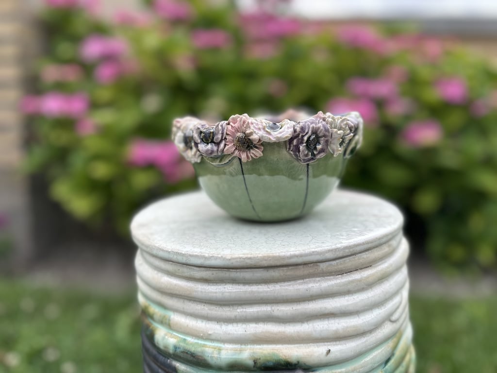 Skål m mange blomster på kant